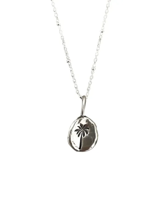 handmade sterling silver necklace with hand stamped palm tree pendant for a beach inspired everyday minimal style necklace.