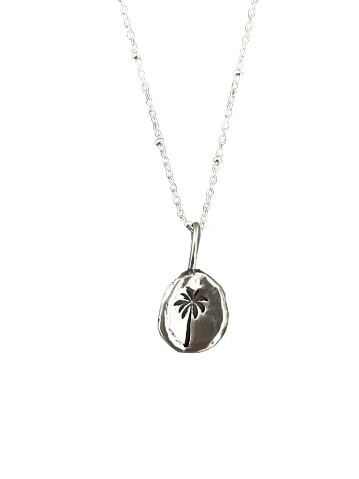 handmade sterling silver necklace with hand stamped palm tree pendant for a beach inspired everyday minimal style necklace.
