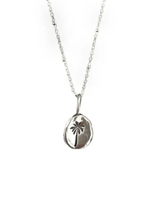 handmade sterling silver necklace with hand stamped palm tree pendant for a beach inspired everyday minimal style necklace.