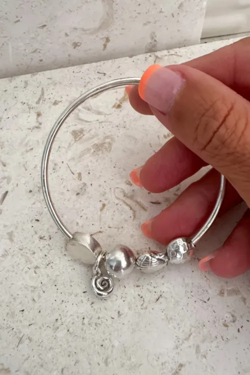 sterling silver bangle with pure silver ball beads and spiral charm tassel. Handmade and ocean inspired. ocean safe and perfect to wear everyday