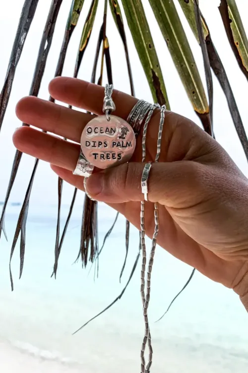 ocean inspired large handmade sterling silver disc pendant on long pure silver chain necklace. 'ocean dips, palms trees' hand stamped onto the silver disc. ocean safe island girl jewellery