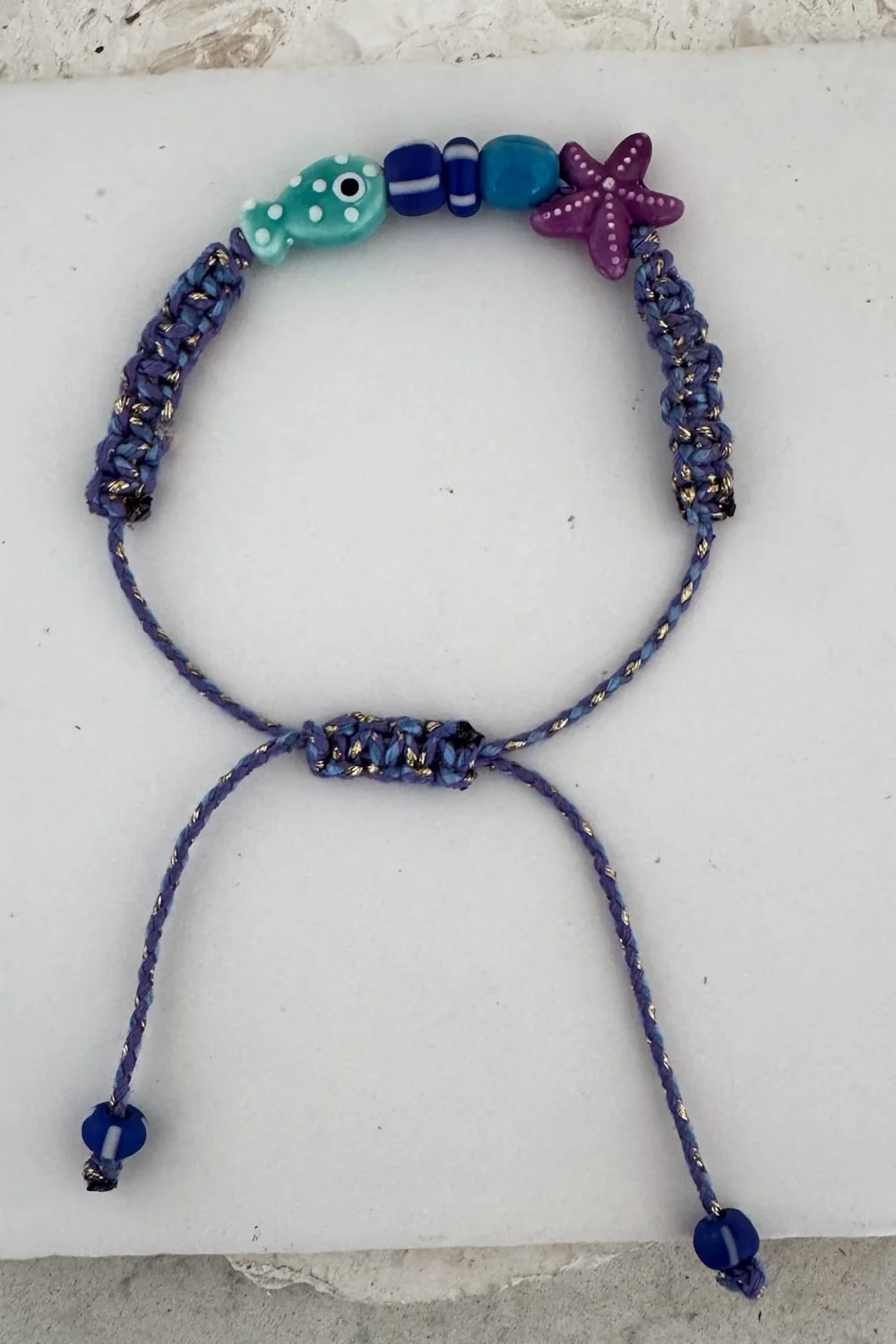 fish macrame bracelet adjustable colourful purple cord. perfect to add colour to a bracelet stack this summer.