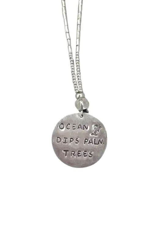 ocean inspired large handmade sterling silver disc pendant on long pure silver chain necklace. 'ocean dips, palms trees' hand stamped onto the silver disc. ocean safe island girl jewellery