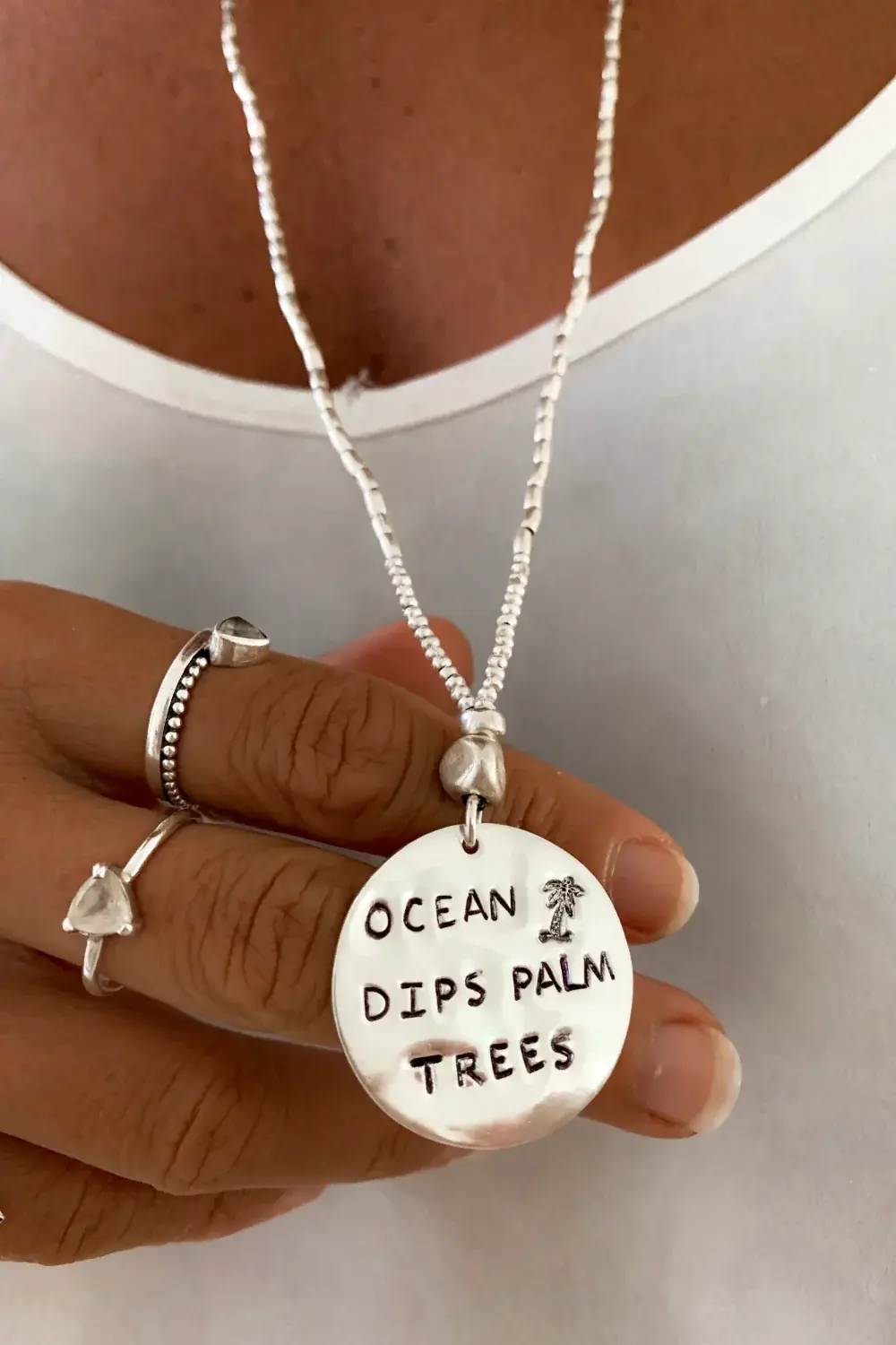 ocean inspired large handmade sterling silver disc pendant on long pure silver chain necklace. 'ocean dips, palms trees' hand stamped onto the silver disc. ocean safe island girl jewellery
