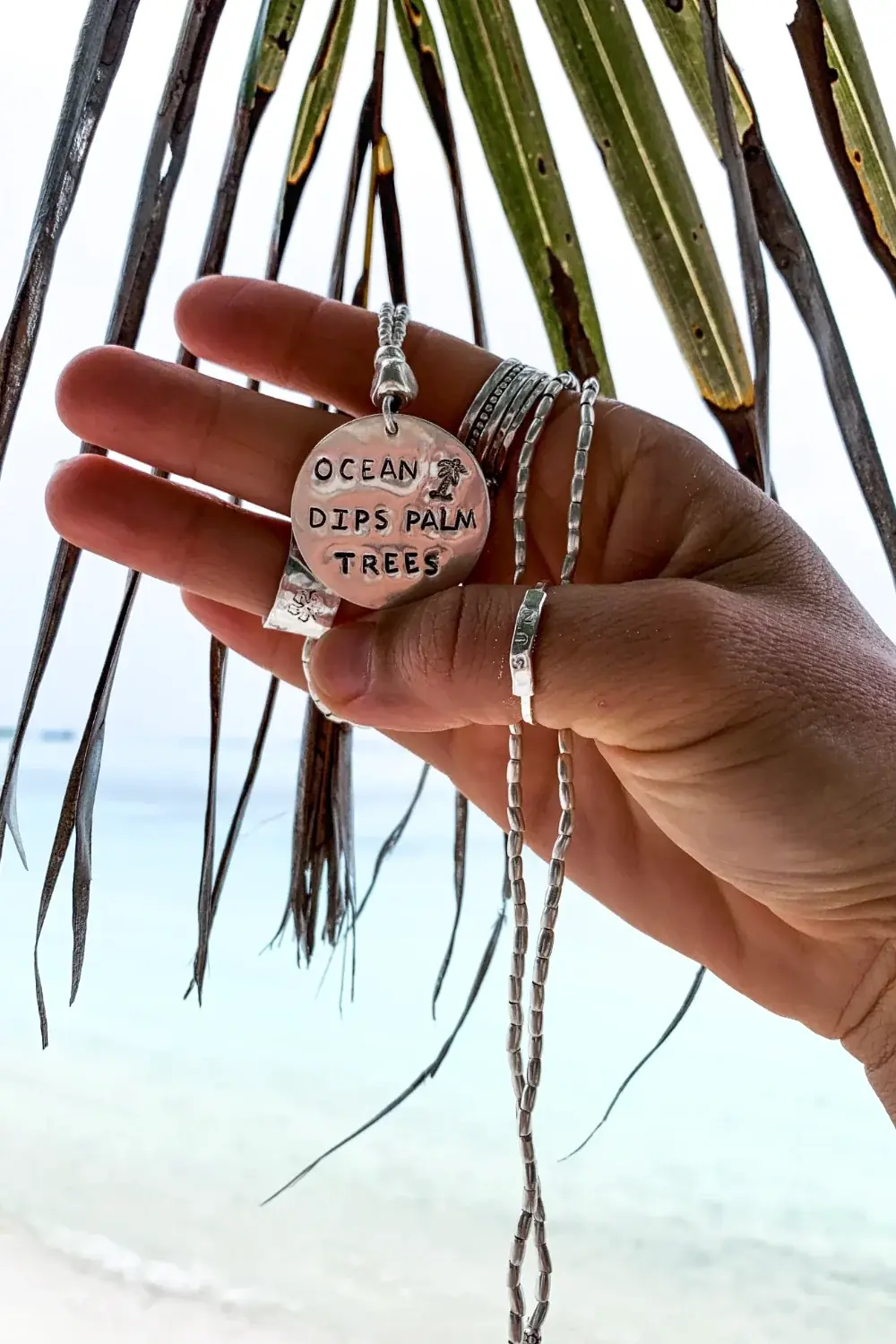ocean inspired large handmade sterling silver disc pendant on long pure silver chain necklace. 'ocean dips, palms trees' hand stamped onto the silver disc. ocean safe island girl jewellery