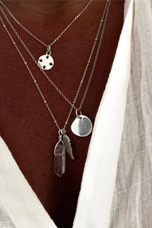 sterling silver necklace with silver feather pendant and crystal quartz pendant. Both floating on a sterling silver chain. Handmade in Sydney Australia. Ocean safe
