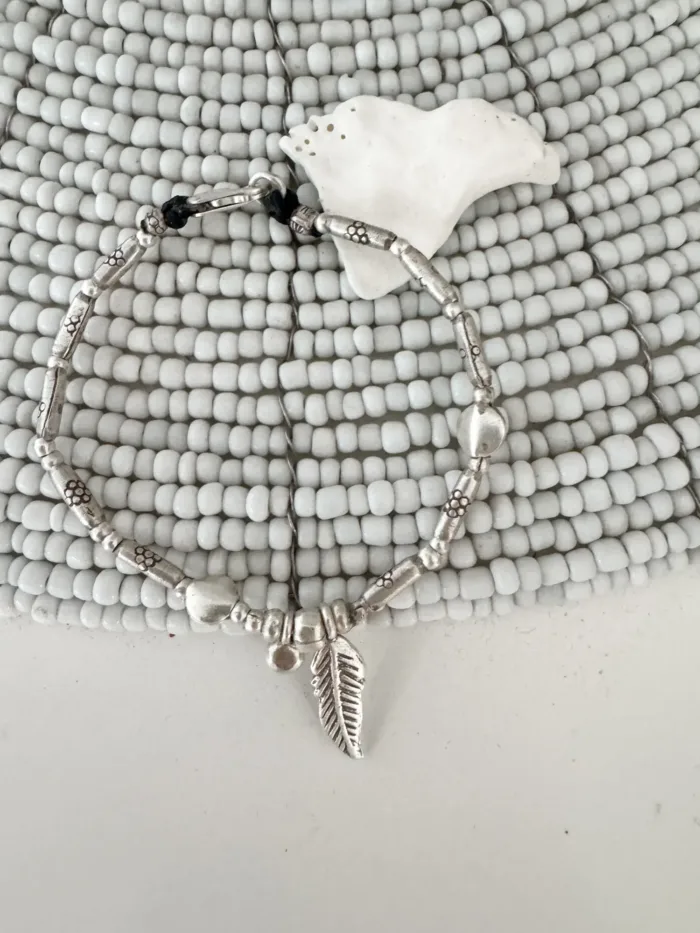 pure silver bracelet boho inspired. feather pendant perfect for everyday wear. ocean safe.
