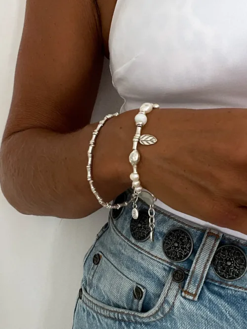 freshwater pearl silver bracelet with lots of charms.