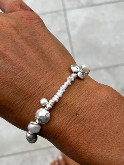 freshwater pearl silver bracelet with lots of charms.