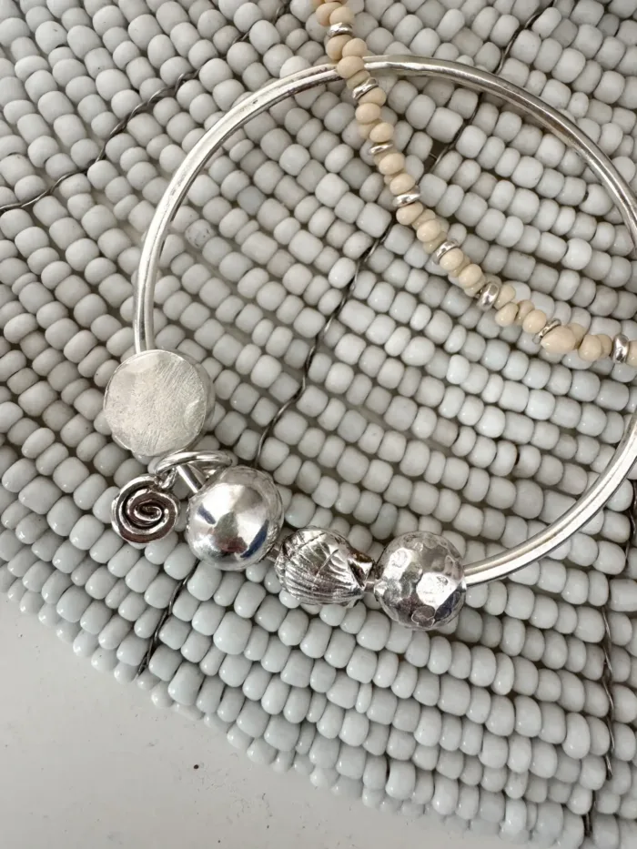 sterling silver bangle with pure silver ball beads and shell charm tassel. Handmade and ocean inspired. ocean safe and perfect to wear everyday