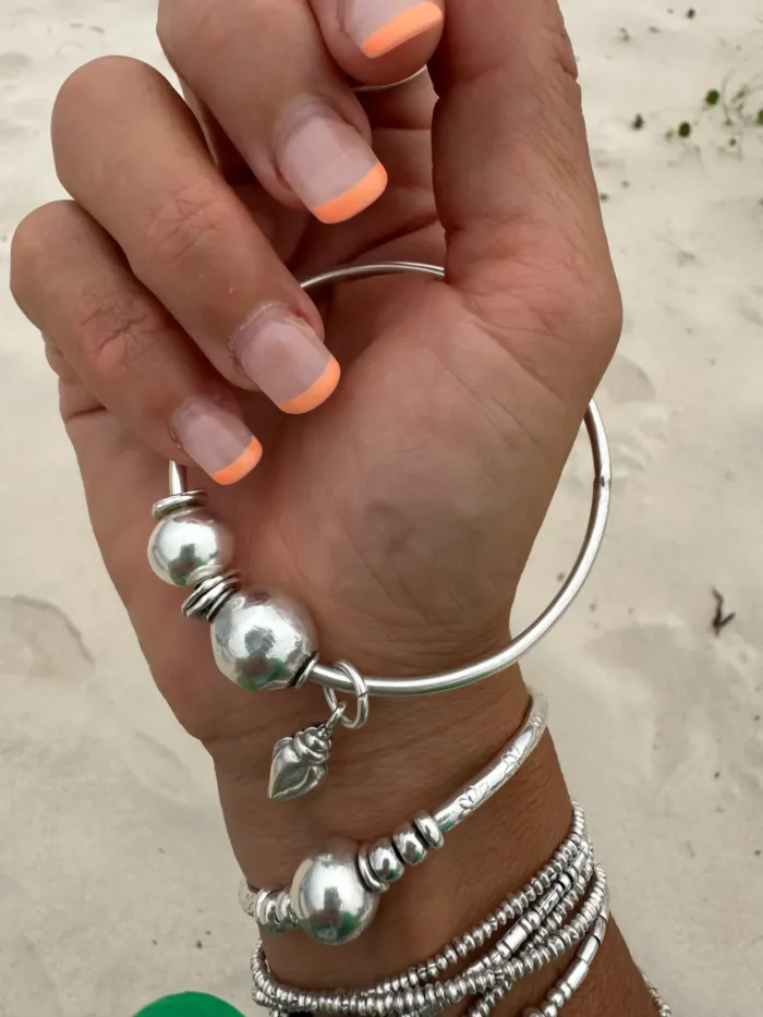 sterling silver bangle with pure silver ball beads and shell charm tassel. Handmade and ocean inspired. ocean safe and perfect to wear everyday