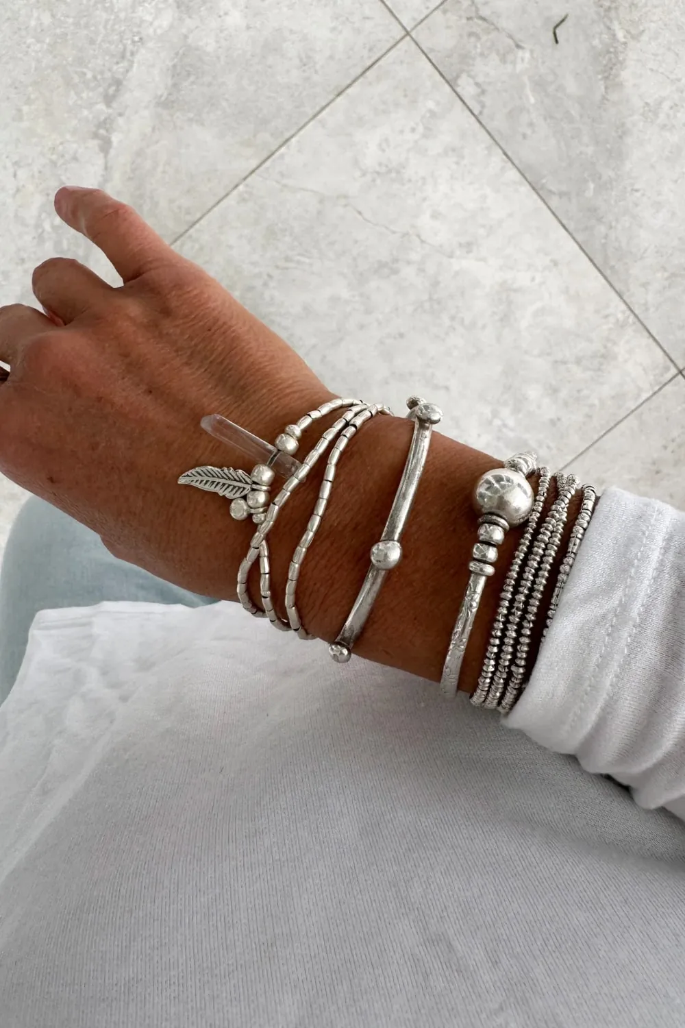 bohemian style silver jewellery. sterling silver wrap bracelet with crystal quartz and feather charm - water safe for everyday wear. 3 styles in 1