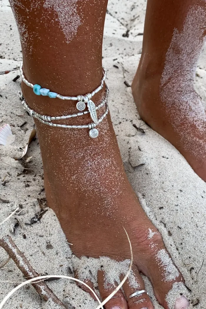 double strand pure silver anklet with large silver leaf and om charm layered with a 2 strand pure silver bracelet with large silver leaf. Ocean safe