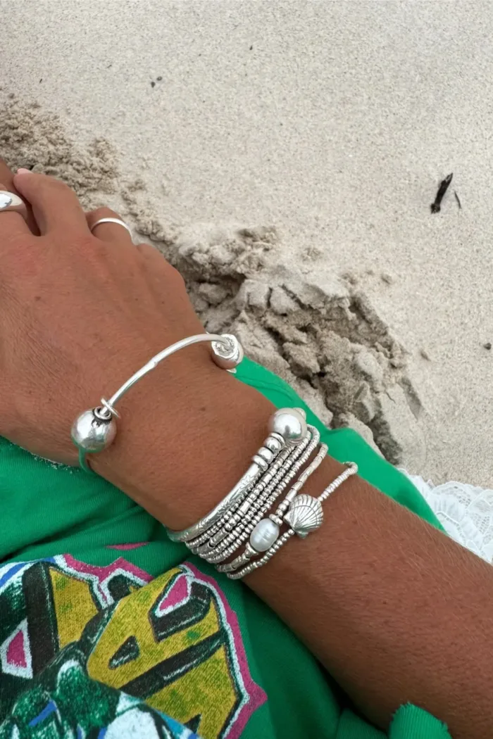 sterling silver bangle with pure silver ball beads and shell charm tassel. Handmade and ocean inspired. ocean safe and perfect to wear everyday
